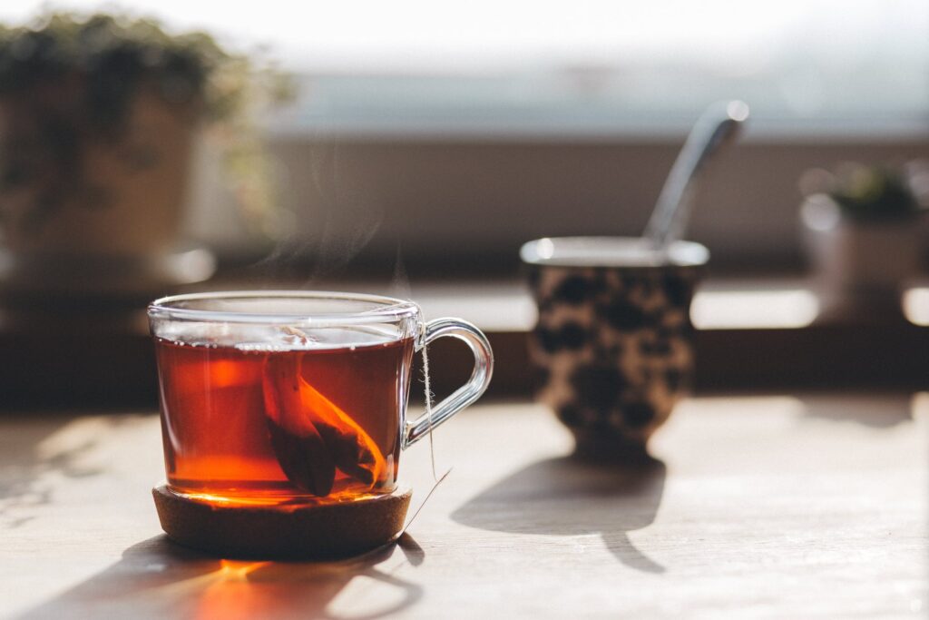 Two Tea Bags In A Clear Mug On A Table.